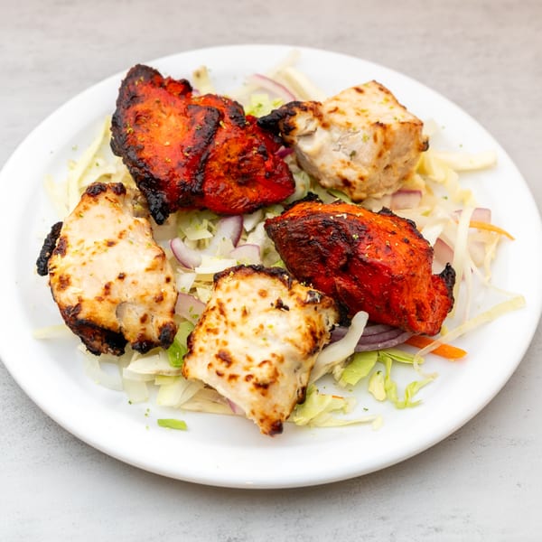 Indian Spice's chicken tikka and malai tikka, served on a bed of shredded cabbage and onions.